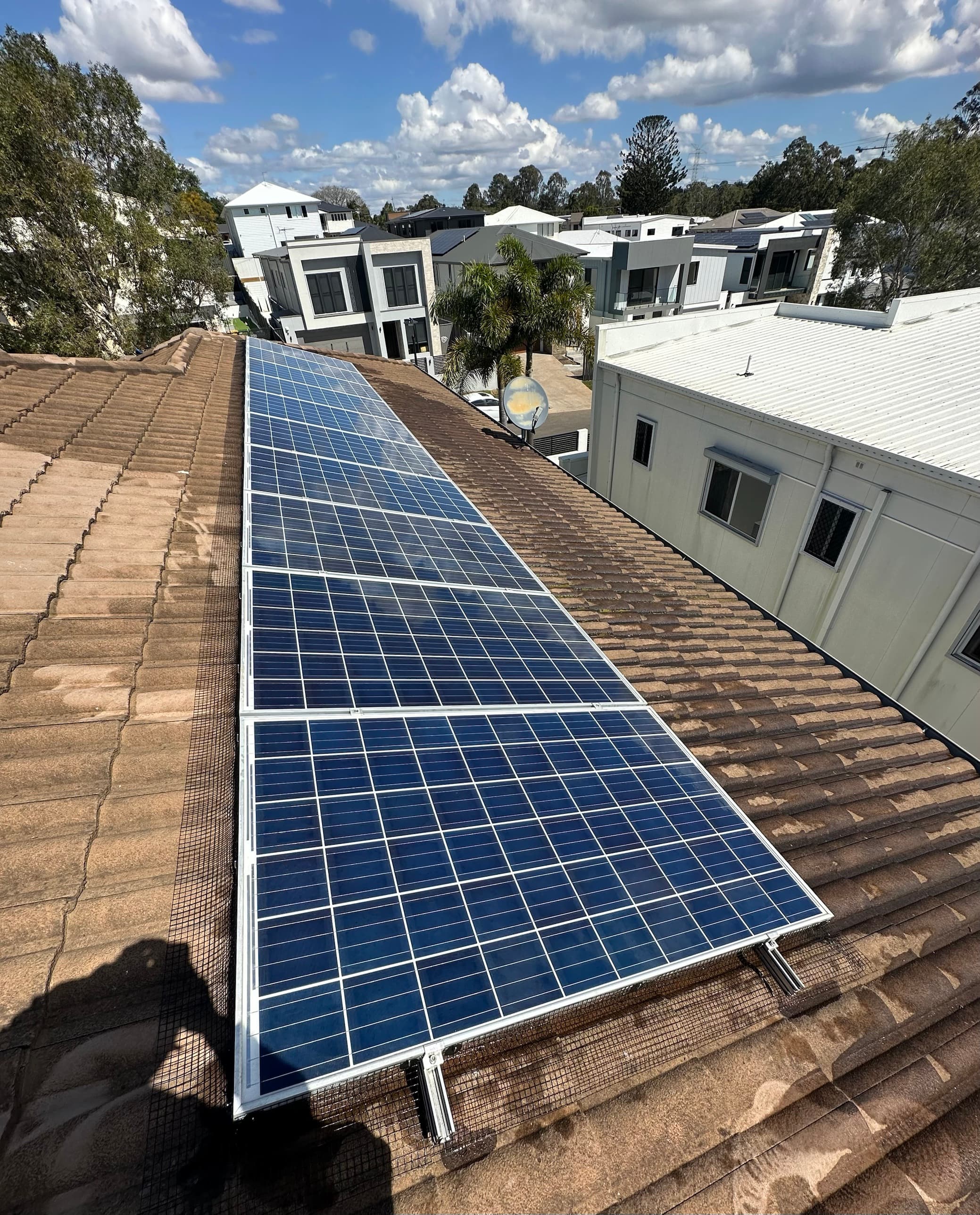 Solar panels on a Brisbane home with pigeon-proofing mesh installed around the edges of the array